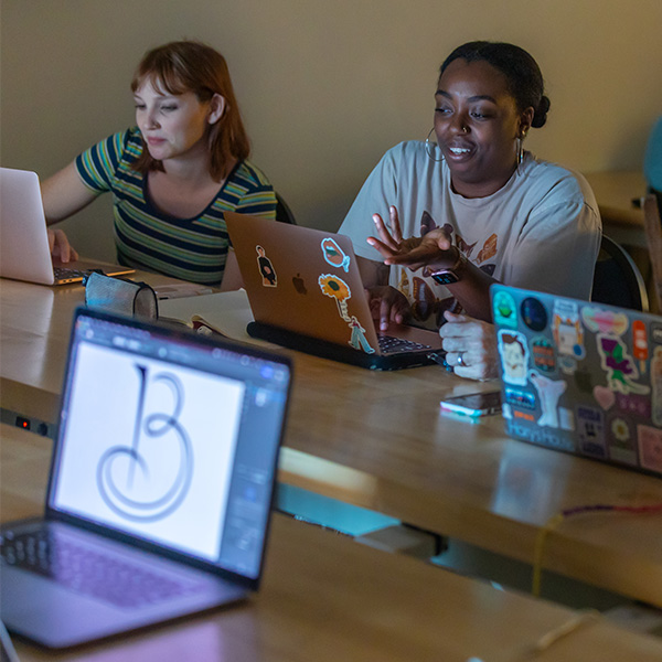 UL Lafayette Graphic design students working on laptops.